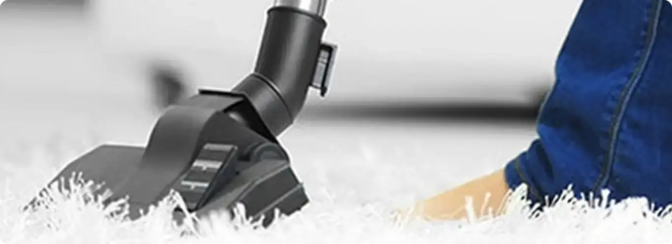 Close-up of a professional vacuuming a white carpet in Mount Pleasant.
